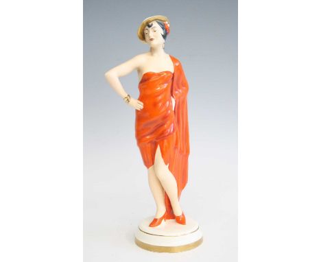 A 1930s Czechoslovakian pottery figure of a standing woman, partially glazed, painted and heightened in gilt, impressed and p