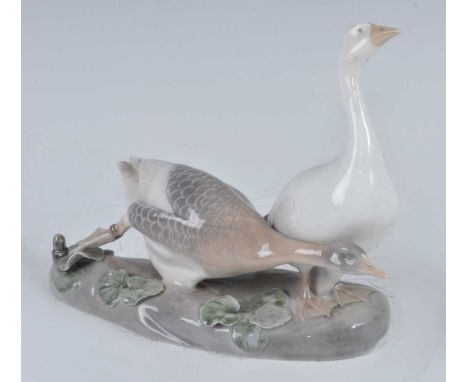 A Royal Copenhagen glazed porcelain model of two geese, raised on naturalistic base, printed backstamp and numbered '1400/609