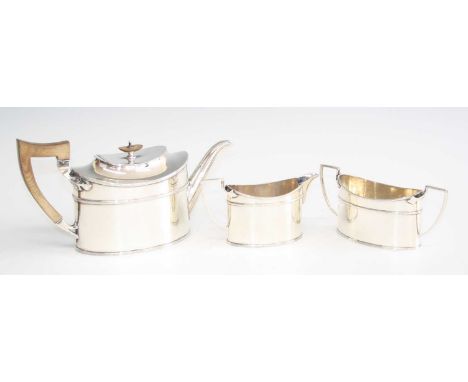 An Art Deco silver three-piece tea set, comprising; teapot with hinged cover, walnut angular handle and finial, twin handled 