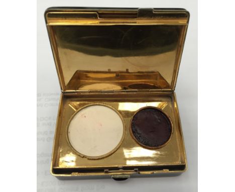 A French Art Deco compact, with black finish and cartouche to the top with dragon and mother-of-pearl and gold detail, openin