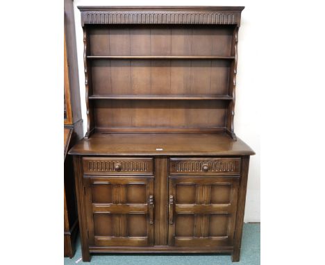 A 20th century Ercol elm and beech kitchen dresser with open plate rack over pair of drawers over pair of cabinet doors, 179c