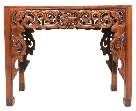 A 20th century Oriental hardwood altar table with extensively carved pierced friezes over square shaped supports, 81cm high x