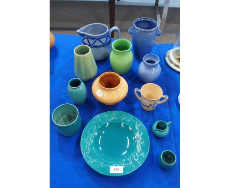 A collection of Ashtead Pottery including a 1930's childs beaker with painted animal decoration, a moulded green glazed deer 