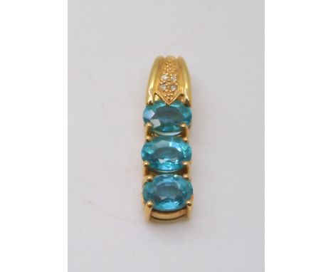 An 18ct gold pendant set with three swimming pool blue apartites and diamond accents, length 3cm, weight 5.4gms Condition Rep