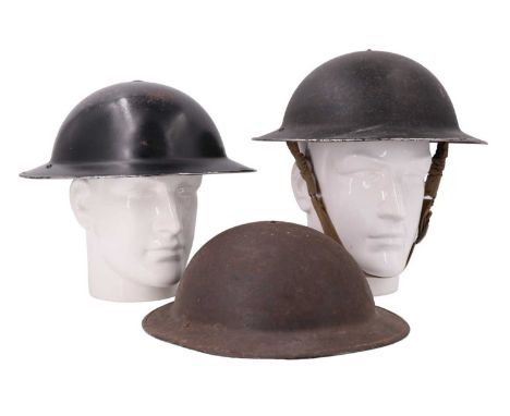 Two Second World War Civil Defence steel helmets together with an Army Mk II helmet
