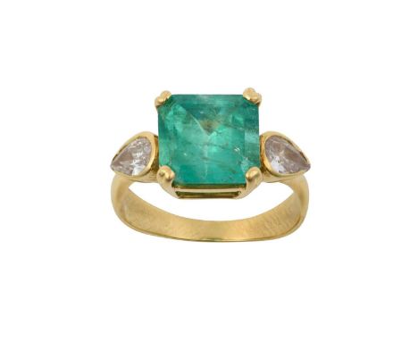 An Emerald and Diamond Three Stone Ringthe emerald-cut emerald in a yellow claw setting, flanked by pear cut diamonds in rubb