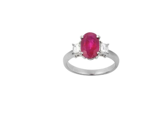 A Ruby and Diamond Three Stone Ringthe oval cut ruby flanked by baguette cut diamonds, in white claw settings, to a tapered s