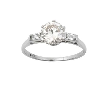 A Diamond Solitaire Ringthe round brilliant cut diamond in a white claw setting, to baguette cut diamond set shoulders, on a 