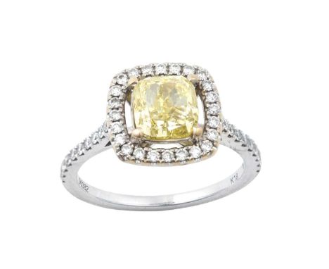A Diamond Cluster Ring the fancy intense yellow cushion cut diamond in a yellow four claw setting, to a spaced border of colo
