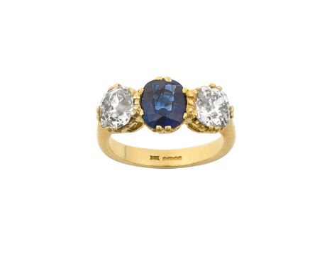 An 18 Carat Gold Sapphire and Diamond Three Stone Ringthe oval cut sapphire flanked by old cut diamonds, in yellow claw setti