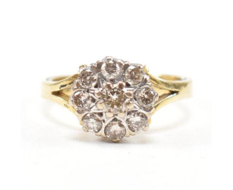 A hallmarked 18ct gold and diamond cluster ring.&nbsp; The ring set with nine round brilliant cut diamonds to bifurcated shou