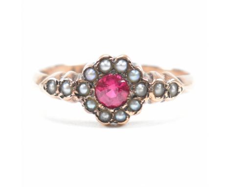 An antique hallmarked 9ct rose gold, synthetic ruby and seed pearl halo ring. The ring having a central round cut ruby encomp