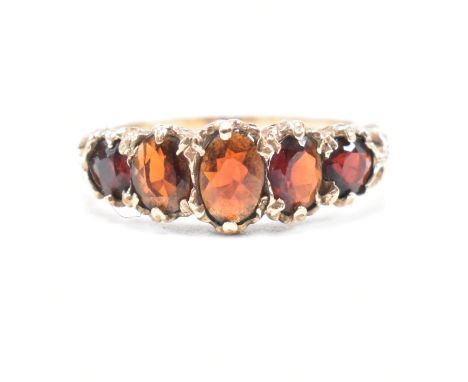 A vintage hallmarked 9ct yellow gold and garnet five stone ring. The antique style ring having five graduated oval and round 