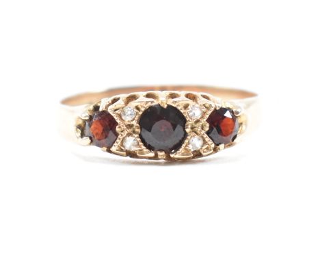 A hallmarked 9ct yellow gold, garnet and spinel ring. The antique style ring having three round cut graduating garnets spaced