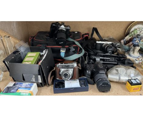 A Panasonic Lumix DMC-GX7 camera together with a Fujifilm  camera, a Kodak Retina automatic I, an Olympus OM-2 camera and acc