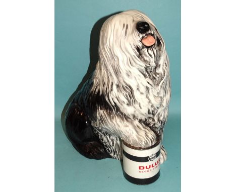 A ceramic fireside figure of the Dulux dog, with front paw resting on a tin of Dulux paint, 33cm high, (probably Beswick but 