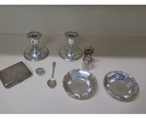 A pair of silver weighted dwarf candlesticks, 8cm tall, a silver top scent bottle with stopper, a silver cigarette case, spoo