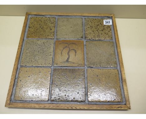 A panel of nine Bernard Leach stoneware tiles each with a decorated grey and oatmeal glaze with the centre painted with a tre