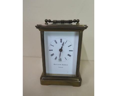 A brass carriage clock Matthew Norman of London, 12cm tall, working with key case and glass good 