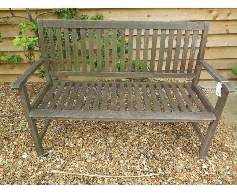 A weathered wooden garden bench, 90cm tall x 130cm x 57cm 