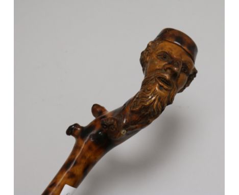 A carved wooden walking stick, with figural handle height 89cm