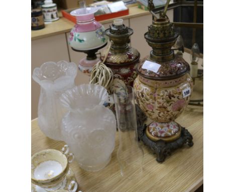 Two pottery oil lamps and a painted glass oil lamp tallest 41cm