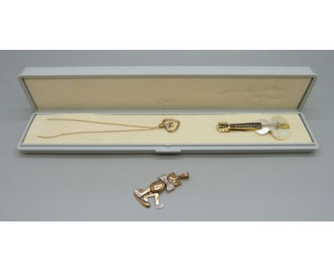 A 9ct gold pendant and chain, 1.4g, a German cat pendant marked 333, 3.8g, and a mother of pearl guitar brooch 