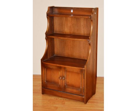 An Ercol open bookcase, with two panelled doors, 110cm high x 61cm wide