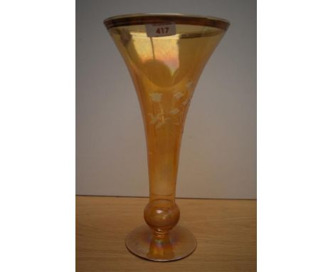 A vintage tinted glass vase of drawn trumpet form with basel knop, wheel engraved with foliate design to the iridescent amber