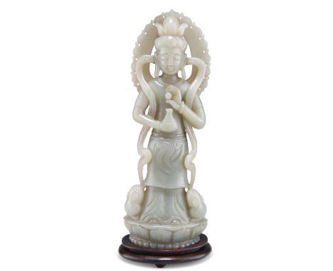 A CHINESE CARVED JADE FIGURE OF GUANYIN, depicted holding a vase and standing upon a lotus, with a hardwood stand. 17cm highC