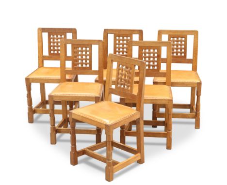 ROBERT THOMPSON OF KILBURN, A SET OF SIX MOUSEMAN OAK DINING CHAIRS, each with lattice back and faceted baluster legs, carved