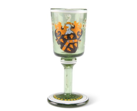 A 19TH CENTURY ARMORIAL GREEN GLASS TOT, with bucket bowl and circular foot, enamel painted with a coat of arms and flowerhea