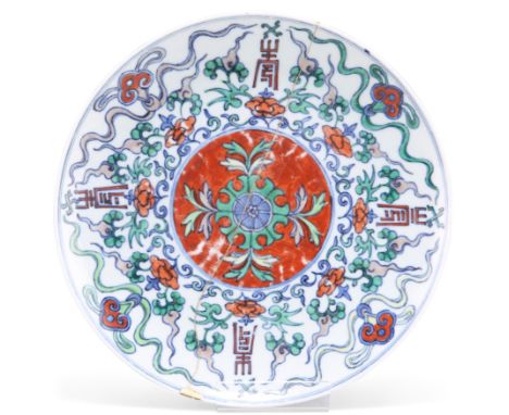 A CHINESE WUCAI DISH, KANGXI, circular, glazed and painted with scrolling foliage, ruyi-heads and symbols, underglaze blue fo