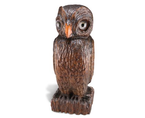 A BLACK FOREST LARGE OWL NEWEL POST FINIAL, with large glass eyes and painted beak, modelled percing upon a square textured b