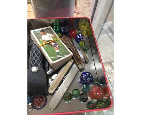 A tin of vintage penknives, badges, tokens and bubble gum cards  
