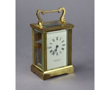 A brass-cased carriage clock with black roman numerals to the white enamel dial signed “GARRARD &amp; Co. Ltd 112 Regent St. 