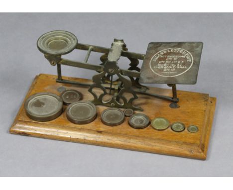 A vintage Mordan &amp; Co. of London brass letter scale with nine brass weights, &amp; mounted on an oak platform base, 12½” 