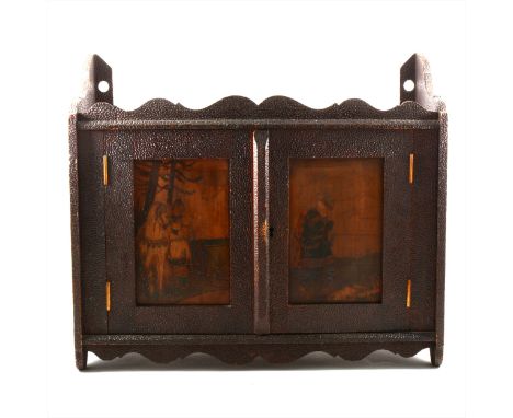 Russian poker-work wall cabinet, two panelled doors, designed with Russian folk scenes, enclosing a single shelf, width 51cm,