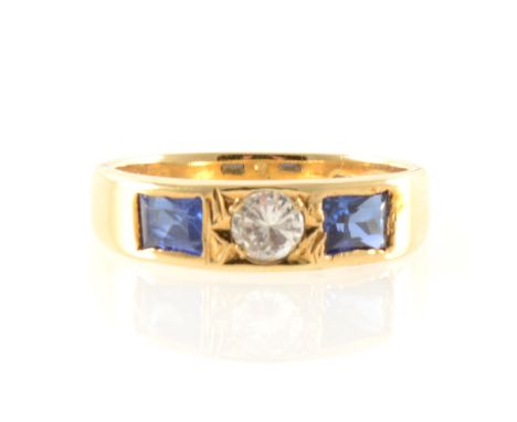 A sapphire and diamond three stone ring, a brilliant cut diamond set in an 18 carat yellow gold tapered band with a rectangul