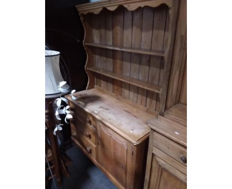 A stripped pine Lincolnshire dresser base, fitted with three drawers and a door, width 123cm, a matched two-shelf delft rack 