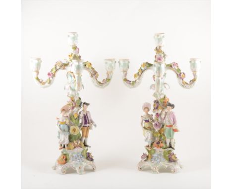 Two German five-light candelabras, late 19th Century, each with four branches encrusted with flowers, the columns modelled wi