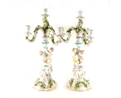 Pair of Continental porcelain four-light figural candelabra, the scrolled branches supported by a column modelled as a woman 
