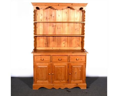 A modern pine dresser, with a two shelf delft rack, the base fitted with three drawers over three panelled doors, width 118cm