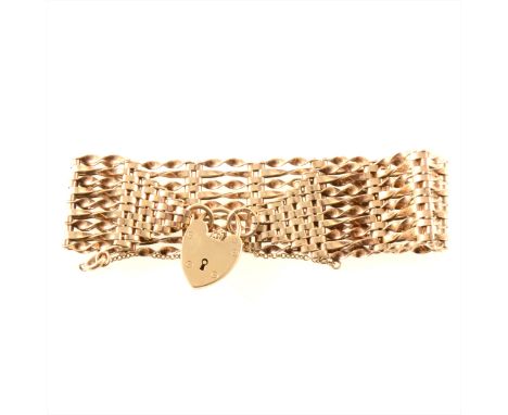 A 9 carat yellow gold ten row gate link bracelet, alternating twisted links and fitted with a padlock fastener, overall width