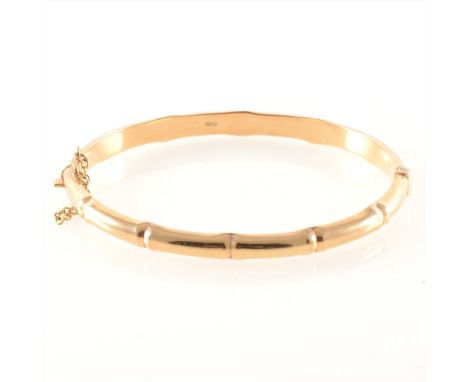 A 9 carat yellow gold hollow half hinged bamboo design bangle, 5.7mm, hallmarked Birmingham 1990, approximate weight 8gms.