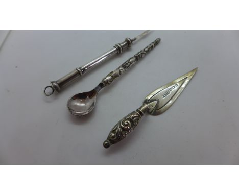 A hallmarked silver trowel page mark7cm long ,A white metal totem pole, spoon and a silver toothpick. Some bending but all re
