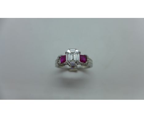 An 18ct white gold diamond and ruby ring with a centre 9 piece diamond, emerald cut measuring 7mm x 5.3mm with diamond set sh