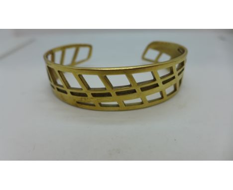 A hallmarked 9ct yellow gold open work bangle 6cm wide x 1.5cm in height, approx 21.6 grams - generally good, some small usag