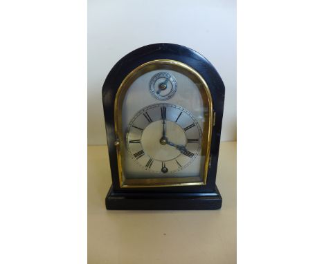 A black ebonised mantle clock with 8 day movement and silvered dial - Height 22cm - running dial good 