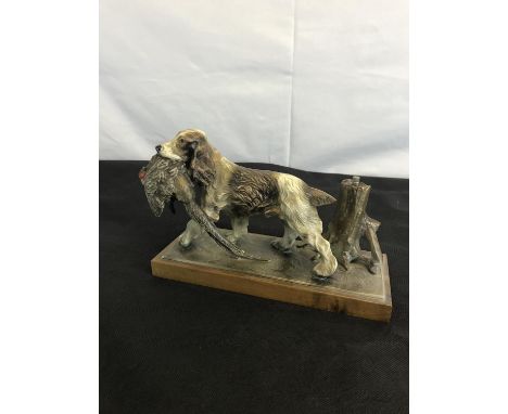 An Art Deco spelter cocker spaniel with pheasant in its mouth figure fitted on a wooden base, Possibly has a lighter with mat